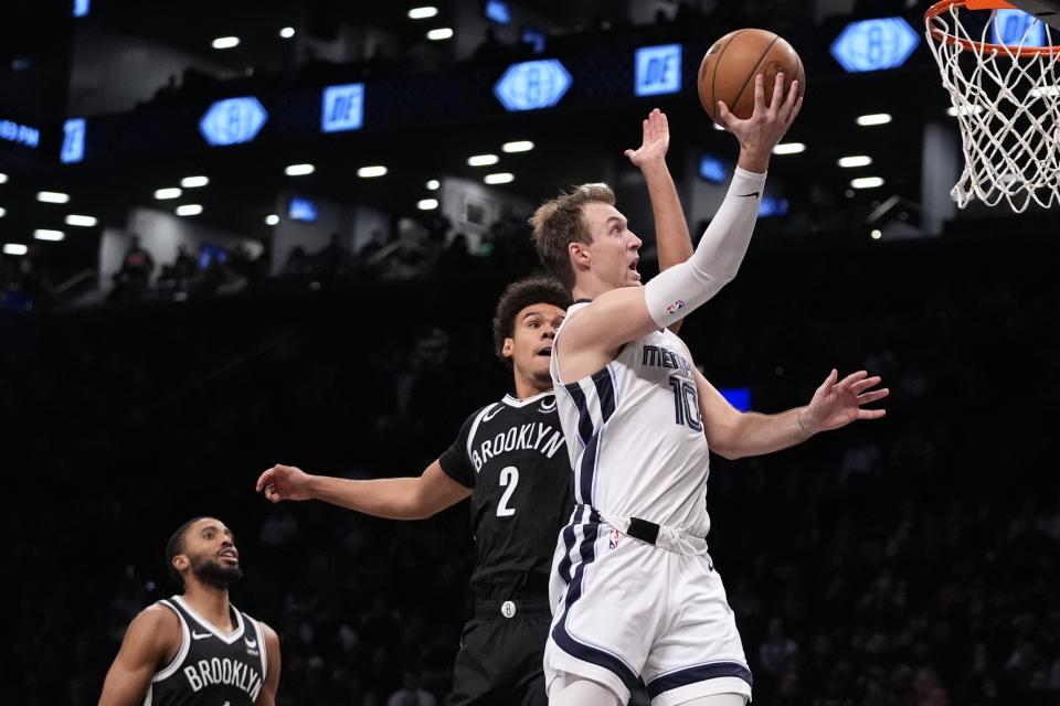 Memphis Grizzlies' Luke Kennard (10) drives past Brooklyn Nets' Cameron Johnson (2) and Mikal Bridges (1) during the second half of an NBA basketball game Monday, March 4, 2024, in New York. (AP Photo/Frank Franklin II)