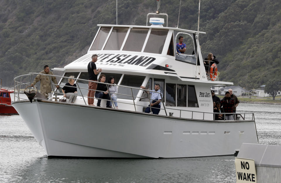 A boat carrying families of victims of the White Island eruption arrive back to the Whakatane wharf following a blessing at sea ahead of the recovery operation off the coast of Whakatane New Zealand, Friday, Dec. 13, 2019. A team of eight New Zealand military specialists landed on White Island early Friday to retrieve the bodies of victims after the Dec. 9 eruption. (AP Photo/Mark Baker)