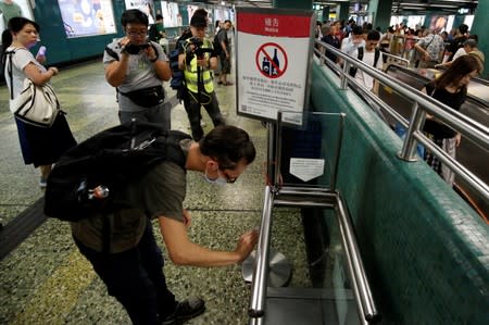 Supporter of the anti-extradition bill cleans the ticket machine as part of the Sham Shui Po Station Cleaning Campaign in Hong Kong