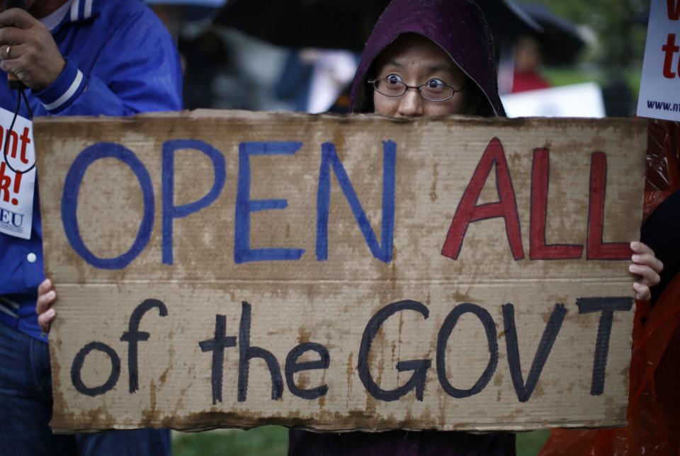 A protester giving only her first name as Nancy holds up a sign calling for an end to the U.S. government shutdown on Capitol Hill in Washington, October 10, 2013. U.S. House of Representatives Republicans are considering signing onto a short-term increase in the government's borrowing authority to buy time for negotiations on broader policy measures, according to a Republican leadership aide. (REUTERS/Jason Reed)