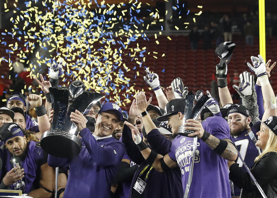 Washington coach Chris Petersen, center left, and defensive back Byron Murphy, center right, celebrate after Washington defeated Utah 10-3 in the Pac-12 Conference championship NCAA college football game in Santa Clara, Calif., Friday, Nov. 30, 2018. (AP Photo/Tony Avelar)
