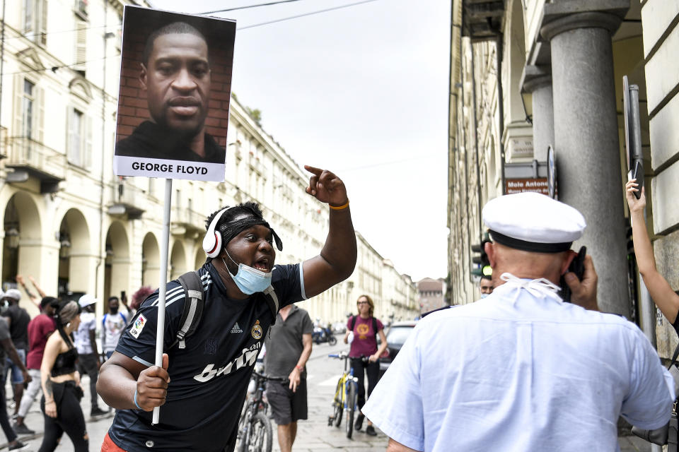 A man holding a picture of George Floyd attends a flash mob calling for justice for George Floyd, who died May 25 after being restrained by police in Minneapolis, USA, in Turin, Italy, Saturday, June 6, 2020. Several hundred people have protested peacefully in Turin, Italy, to denounce the police killing of George Floyd and show solidarity with anti-racism protests in the U.S. and elsewhere. (Fabio Ferrari/LaPresse via AP)