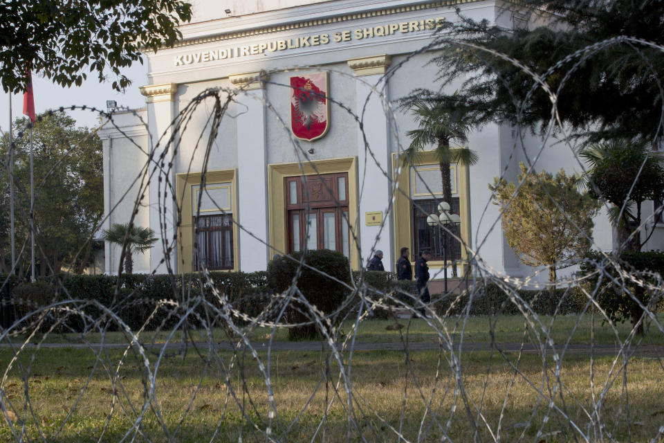 Policemen are seen behind barbwire placed to secure the Parliament building as opposition supporters gather to participate in an anti-government rally in capital Tirana, Albania, on Tuesday, Feb. 21, 2019. Albania’s opposition supporters have surrounded the parliament building Thursday, asking for the resignation of the government which they allege is corrupt. (AP Photo/Visar Kryeziu)