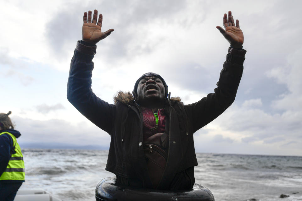 In this Saturday, Feb. 29, 2020 photograph a man reacts as he arrives with other migrants at the village of Skala Sikaminias, on the Greek island of Lesbos, after crossing the Aegean sea from Turkey. The United Nations migration organization said Sunday that at least 13,000 people were massed on Turkey's land border with Greece, after Turkey officially declared its western borders were open to migrants and refugees hoping to head into the European Union. (AP Photo/Michael Varaklas)