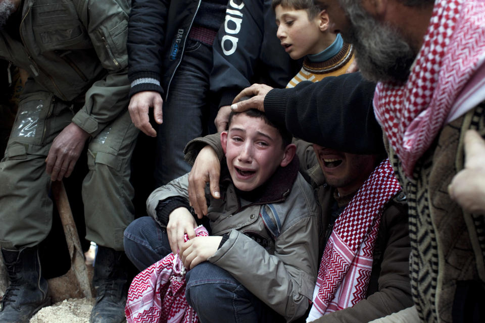 FILE - In this Thursday, March 8, 2012 file photo, Ahmed, center, mourns his father Abdulaziz Abu Ahmed Khrer, who was killed by a Syrian Army sniper, during his funeral in Idlib, north Syria. Syria’s uprising was not destined to be quick. Instead, the largely peaceful protest movement that spread across the nation slowly turned into an armed insurgency and eventually a full-blown civil war. More than 130,000 people have been killed, and more than 2 million more have fled the country. (AP Photo/Rodrigo Abd, File)