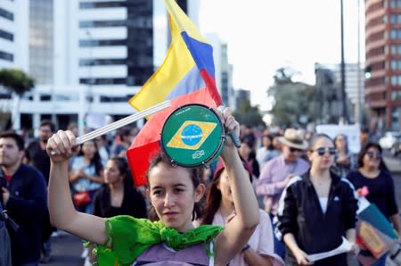 A demonstrator bangs a tambourine bearing the flag of Brazil during a protest to demand more Amazon rainforest protection at the embassy of Brazil in Quito