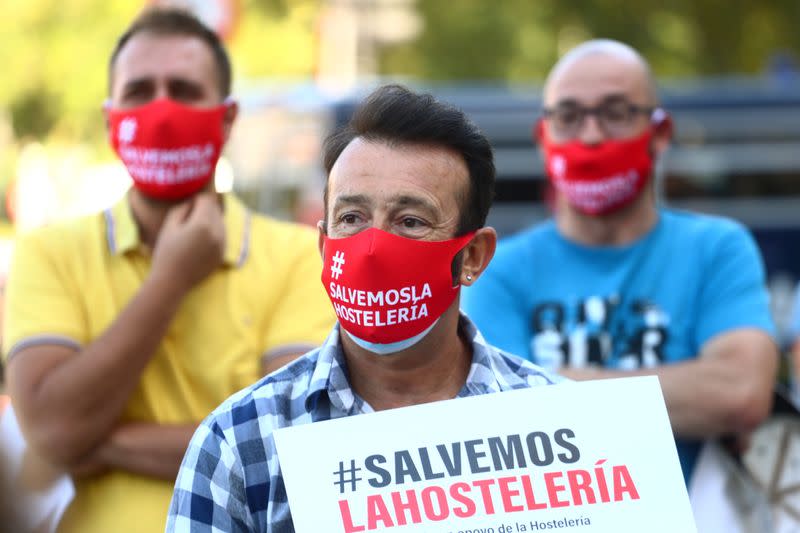 Demonstrators wear protective face masks reading "Save the hostelry sector" as they attend a protest in Madrid