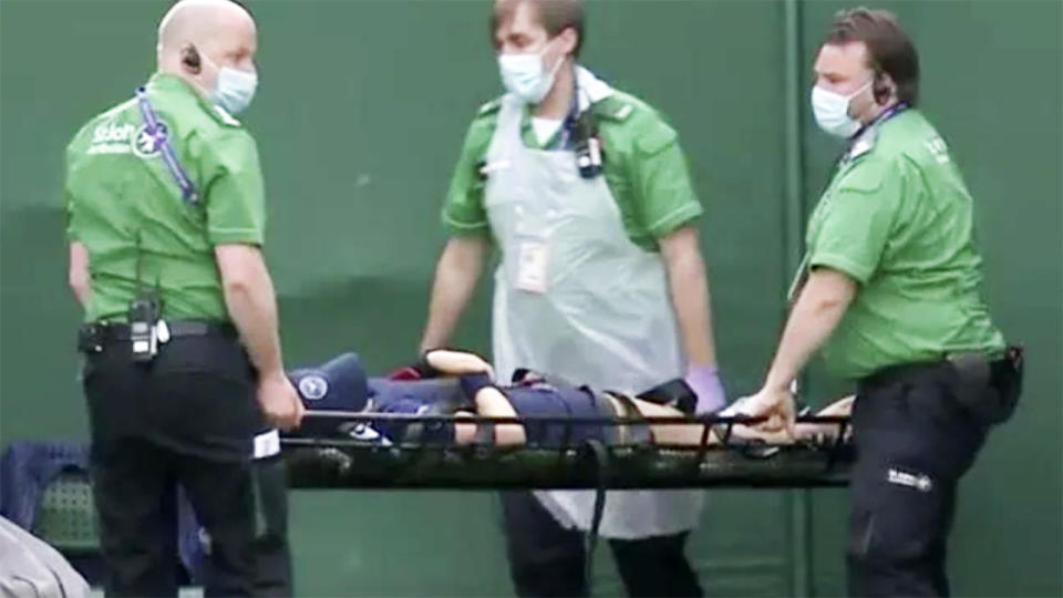 The ball kid, pictured here being taken from the court on a stretcher.