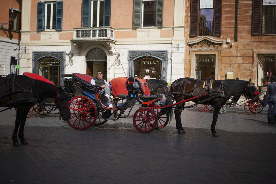 A Botticella (traditional Roman horse-driven touristic carriage) driver waits for customers in Piazza di Spagna, at the bottom of the Spanish Steps, in Rome, Thursday, March 5, 2020. Italy's virus outbreak has been concentrated in the northern region of Lombardy, but fears over how the virus is spreading inside and outside the country has prompted the government to close all schools and Universities nationwide for two weeks. (AP Photo/Andrew Medichini)