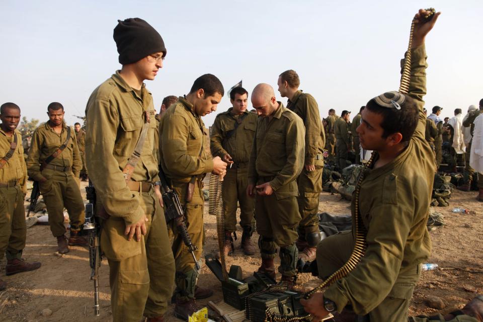 ISRAEL/GAZA BORDER, ISRAEL - NOVEMBER 19: (ISRAEL OUT) Israeli soldiers prepare weapons in a deployment area on November 19, 2012 on Israel's border with the Gaza Strip. The death toll has risen to at least 85 killed in the air strikes, according to hospital officials, on day six since the launch of operation 'Pillar of Defence.' (Photo by Lior Mizrahi/Getty Images)
