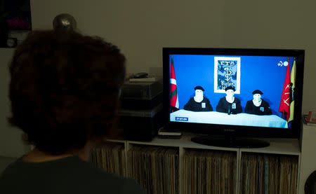 A woman watches a news program announcing the dissolution of armed Basque separatists ETA due for the first week of May, according to local television station ETB, in Guernica, April 18, 2018. REUTERS/Vincent West