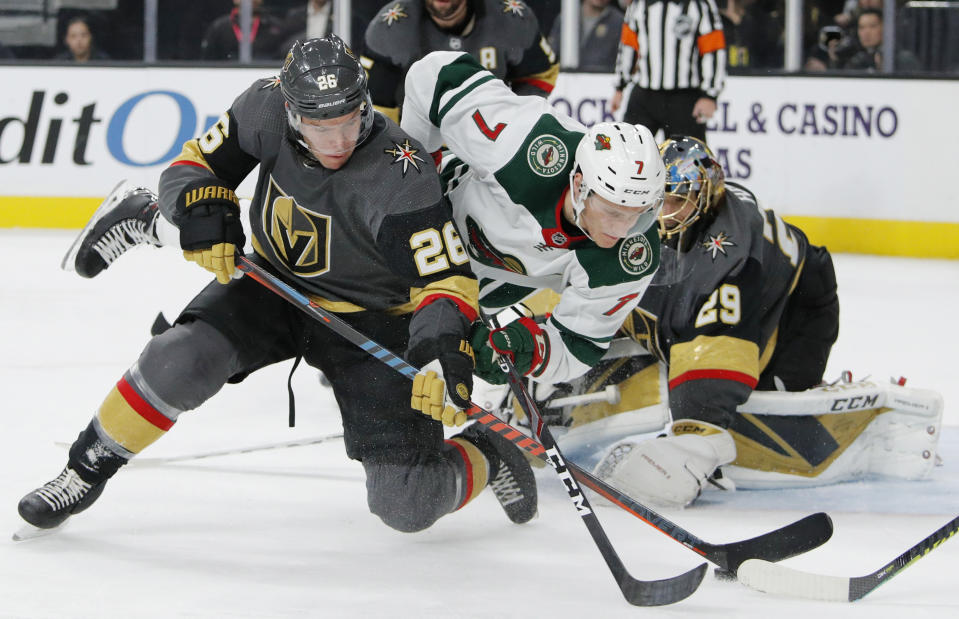 FILE - In this Dec. 17, 2019, file photo, Vegas Golden Knights center Paul Stastny (26) and Minnesota Wild's Nico Sturm (7) vie for the puck during the third period of an NHL hockey game in Las Vegas. The Wild have re-signed Sturm to a two-year, $1.45 million contract. (AP Photo/John Locher, File)