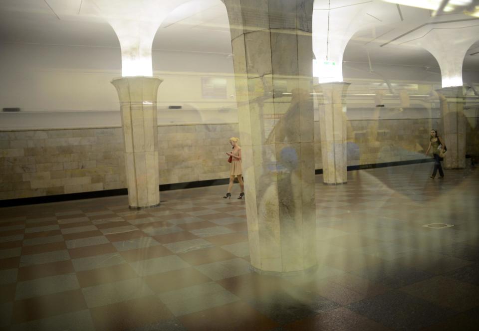 Passengers walk down a concourse at a metro station in Moscow August 10, 2013. To step onto the Moscow metro is to step back in time and immerse yourself in a museum rich in architecture and history. Opened in 1935, it is an extravagant gallery of Communist design, featuring Soviet artworks, statues, chandeliers, stained glass and ceiling mosaics. Built under Stalin, the metro now transports 7 to 9 million people a day and costs 30 Rubles, around $1, for a single ride. Picture taken August 10, 2013. REUTERS/Dylan Martinez (RUSSIA - Tags: TRANSPORT SOCIETY) ATTENTION EDITORS: PICTURE 24 OF 24 FOR PACKAGE 'RIDING THE MOSCOW METRO' SEARCH 'MOSCOW CHANDELIERS' FOR ALL IMAGES