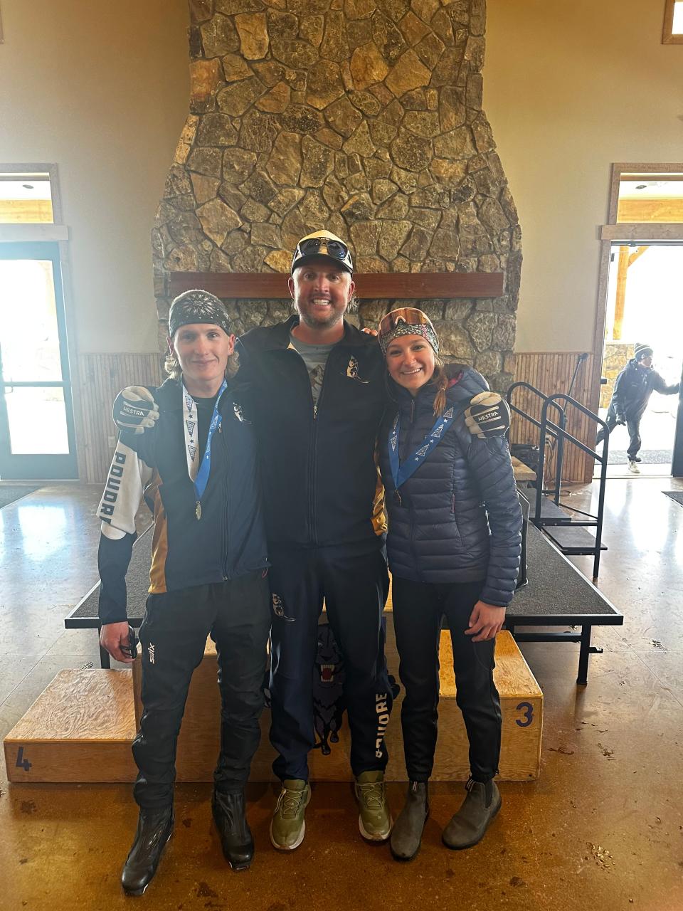 PSD Nordic ski coach Kyle Steitz (middle) stands with 5-kilometer skate podium finishers Cade Shortridge (left) and Clara Statkus (right) at the Colorado state Nordic ski championships on Thursday, Feb. 22, 2024, at YMCA of the Rockies Snow Mountain Ranch in Granby, Colo.