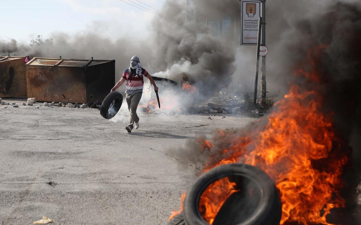 Palestinian protesters burn tires on the blockaded Gaza Strip near Beit El checkpoint in Ramallah, West Bank. The two main militant groups are disagreeing over how to deal with Israel - Anadolu