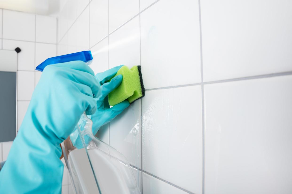 close-up of person cleaning the tiled wall