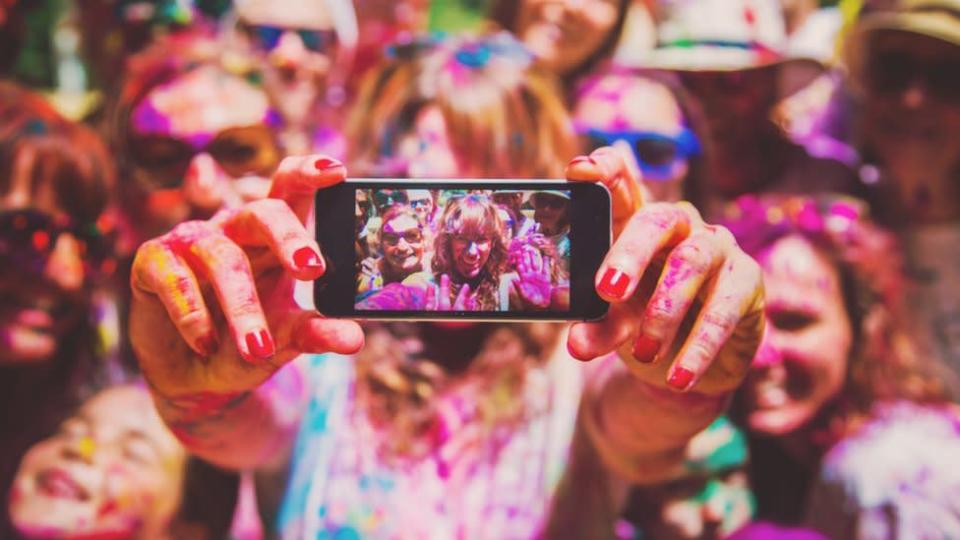 Un grupo de amigos en una fiesta tomándose una foto para Instagram