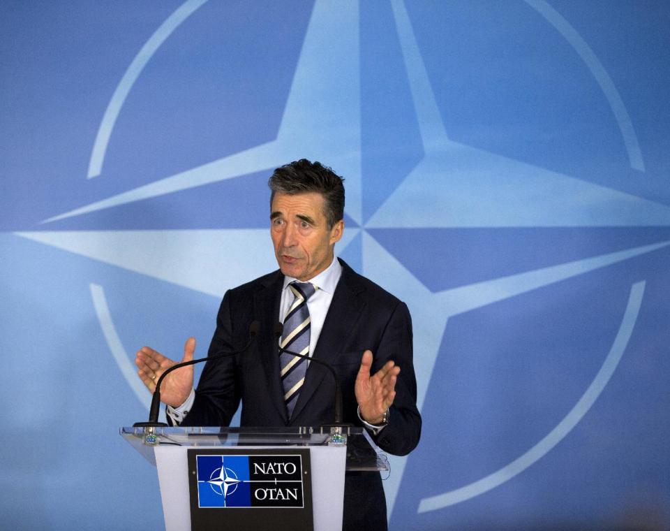 NATO Secretary General Anders Fogh Rasmussen walks away with his papers after speaking at a media conference at NATO headquarters in Brussels on Sunday, March 2, 2014. NATO called for emergency talks on Sunday regarding the escalating crisis in Ukraine. (AP Photo/Virginia Mayo)