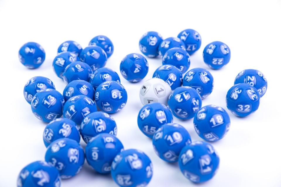 One white Powerball sits amongst a number of blue balls used in lottery draws. 