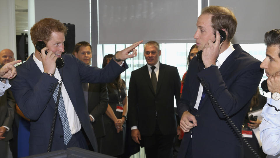 FILE - Britain's Prince William, Duke of Cambridge, right and his brother Prince Harry take part in a trade on the BGC Partners trading floor, during the BGC Charity Day 2013, in Canary Wharf, London, Wednesday, Sept. 11, 2013. Court papers say that Prince William quietly received “a very large sum of money” in a 2020 phone hacking settlement with the British newspaper arm of Rupert Murdoch’s media empire. Court documents aired Tuesday in one of his brother’s lawsuits against British newspapers says the Prince of Wales, heir to the British throne, quietly received a settlement in 2020. (AP Photo/ Chris Jackson, Pool, File)