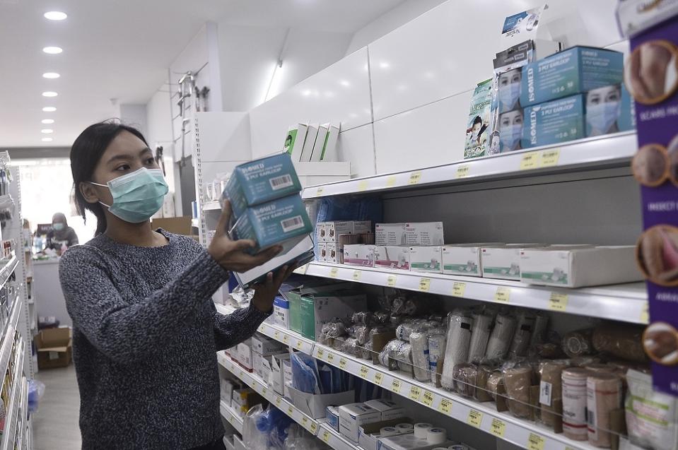 A sales assistant arranges boxes of face masks at a Pharmhouse Pharmacy outlet in Setia Alam on January 28, 2020. — Picture by Miera Zulyana