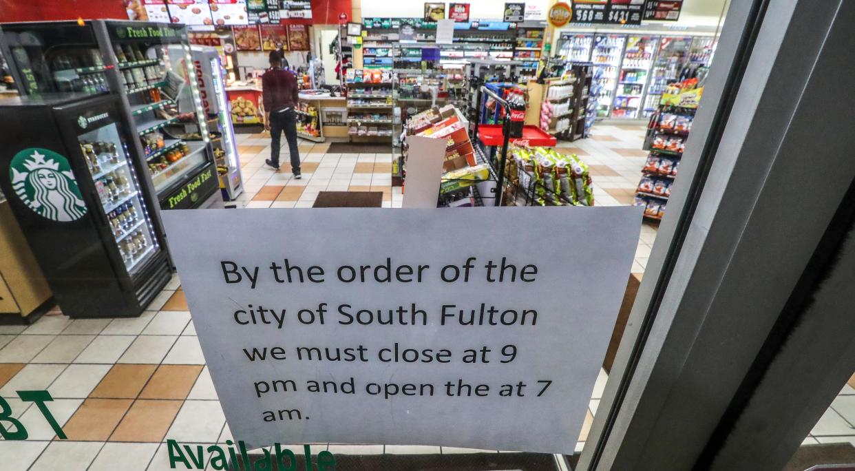 A sign at a store in South Fulton, Ga., lets customers know about the city's curfew because of the coronavirus, on Thursday, March 19, 2020.