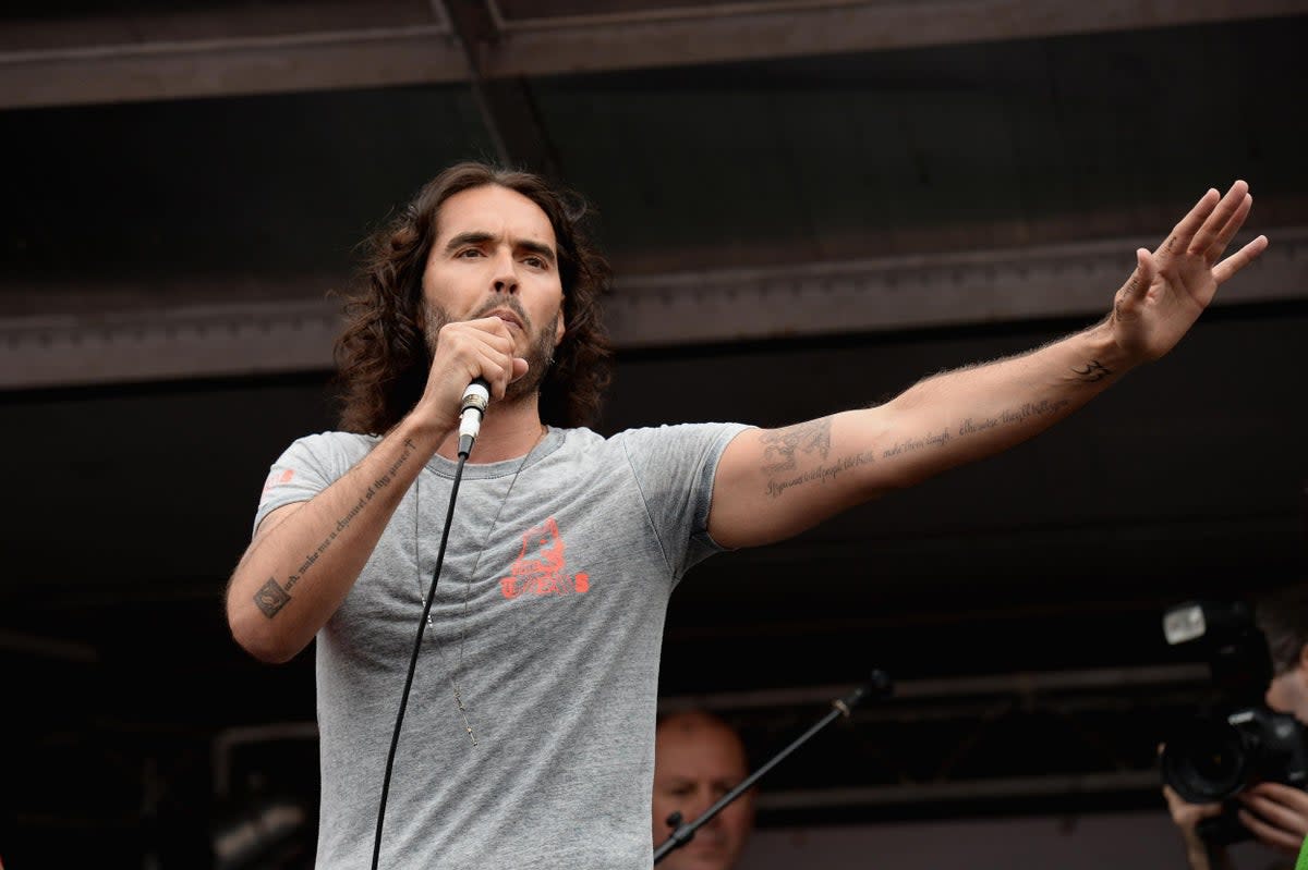 Comedian Russell Brand speaks to thousands of demonstrators gathered in Parliament Square to protest against austerity and spending cuts in 2015 (Getty)