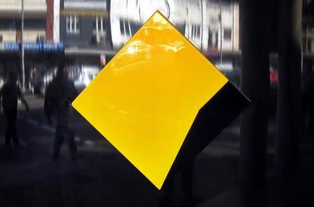 Pedestrians are reflected in a logo as they walk past a branch of the Commonwealth Bank of Australia (CBA) in Sydney, Australia, October 10, 2015. REUTERS/David Gray