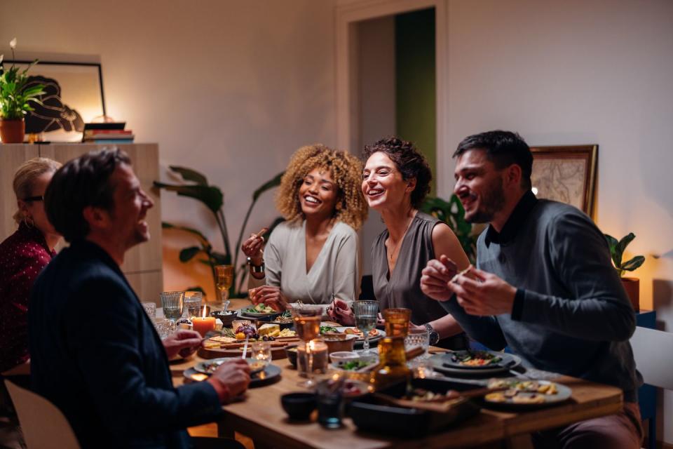 friends laughing having dinner together