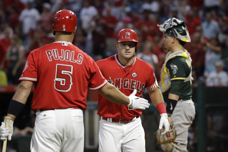 Los Angeles Angels’ Mike Trout (center) celebrates his home run with Albert Pujols (left). (AP)