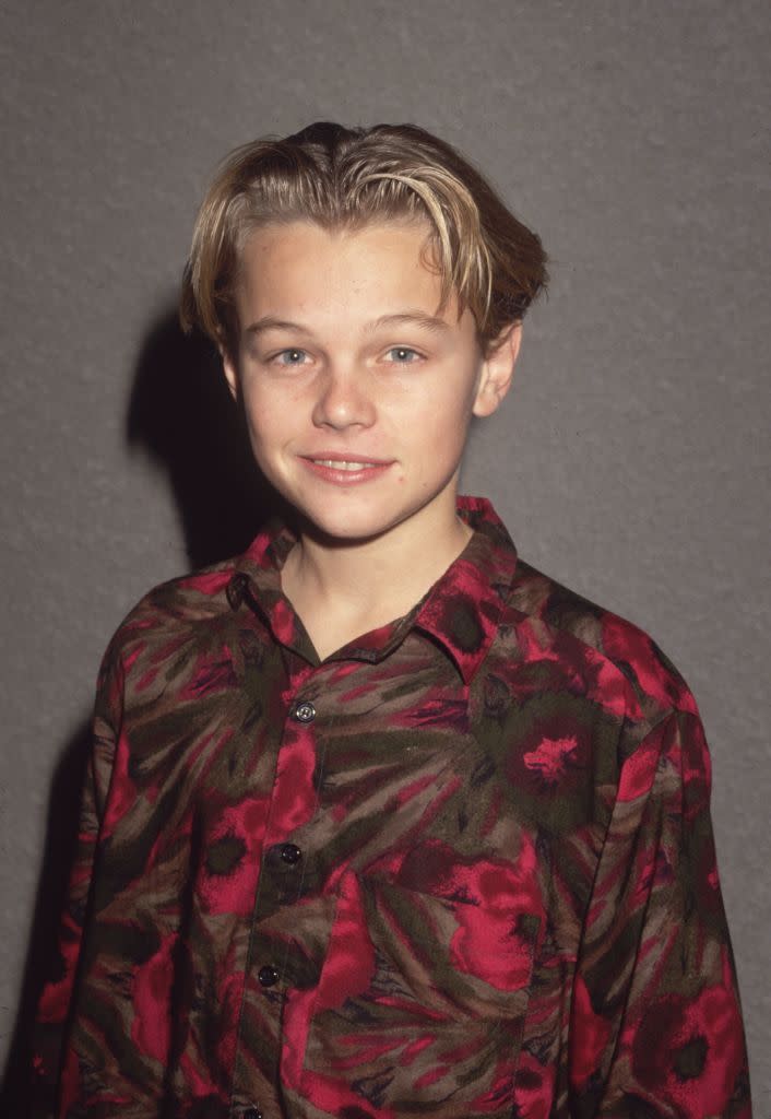 leonardo dicaprio as a child, wearing a red patterned button shirt