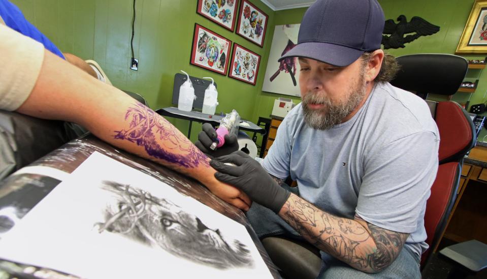 Lee Greene works on the arm of Seth Willis Thursday afternoon, April 18, 2024, at Greeneworks Tattoo in Shelby.