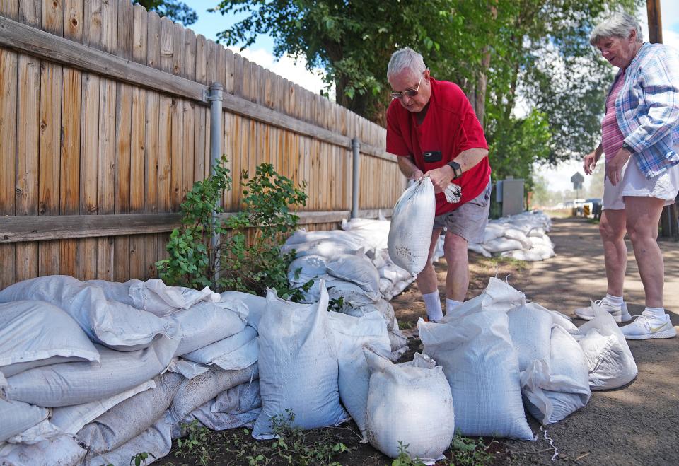 Glen Hunter moves sandbags to remove a small bush and solidify the wall of bags protecting his property from flooding prior to more thunderstorms in the afternoon of Aug. 9, 2022, in Flagstaff. Glen and his wife Mary Ann have lived there for 35 years and have never had flooding.