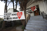 Signs are posted outside of a house that was occupied by homeless women in Oakland, Calif., Tuesday, Jan. 14, 2020. Homeless women ordered by a judge last week to leave a vacant house they occupied illegally in Oakland for two months have been evicted by sheriff's deputies. They removed two women and a male supporter Tuesday from the home before dawn in a case highlighting California's severe housing shortage and growing homeless population. (AP Photo/Jeff Chiu)