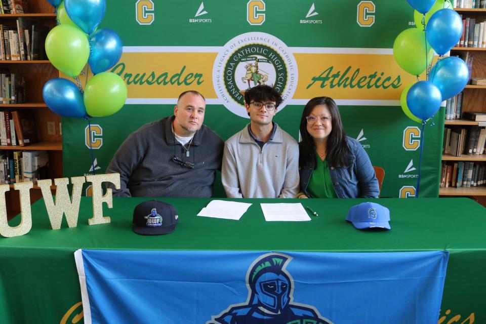 Pensacola Catholic's Xander McLaughlin (middle) recently signed his letter of intent to compete at the University of West Florida in cross country.