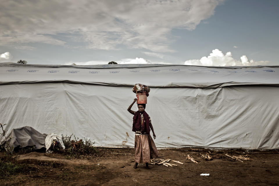 A Burundian woman carries laundry at the Gashora refugee camp in Gashora, Bugesera, Rwanda Wednesday April 29, 2015.