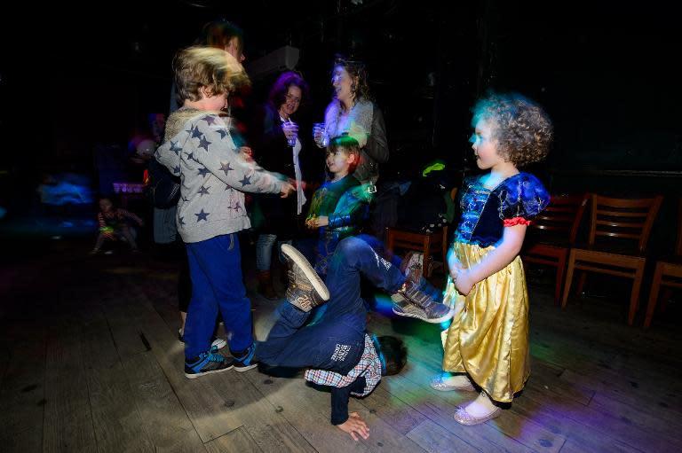 Four-year-old Tehya (R) watches a boy breakdance as she enjoys the music and entertainment at the Big Fish Little Fish "2-4 Hour Party People" event in Brixton, South London, on April 12, 2014