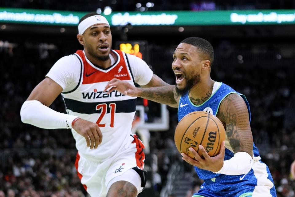 Milwaukee Bucks' Damian Lillard drives to the basket against Washington Wizards' Daniel Gafford (21) during the first half of an NBA basketball In-Season Tournament game Friday, Nov. 24, 2023, in Milwaukee. (AP Photo/Aaron Gash)