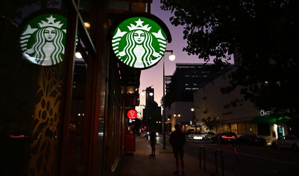 People stand outside a Starbucks closed for the day in Los Angeles, California on July 12, 2022. The coffee chain is currently facing a lawsuit over a guest who said she received severe burns at a Starbucks drive-thru in Los Angeles in February 2022.