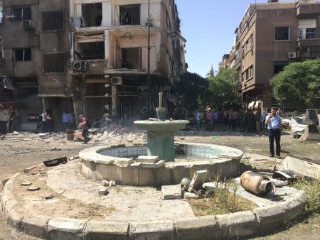 People inspect the damage at the site of a suicide attack in Tahrir Square, in central Damascus, Syria July 2, 2017. REUTERS/Firas Makdesi