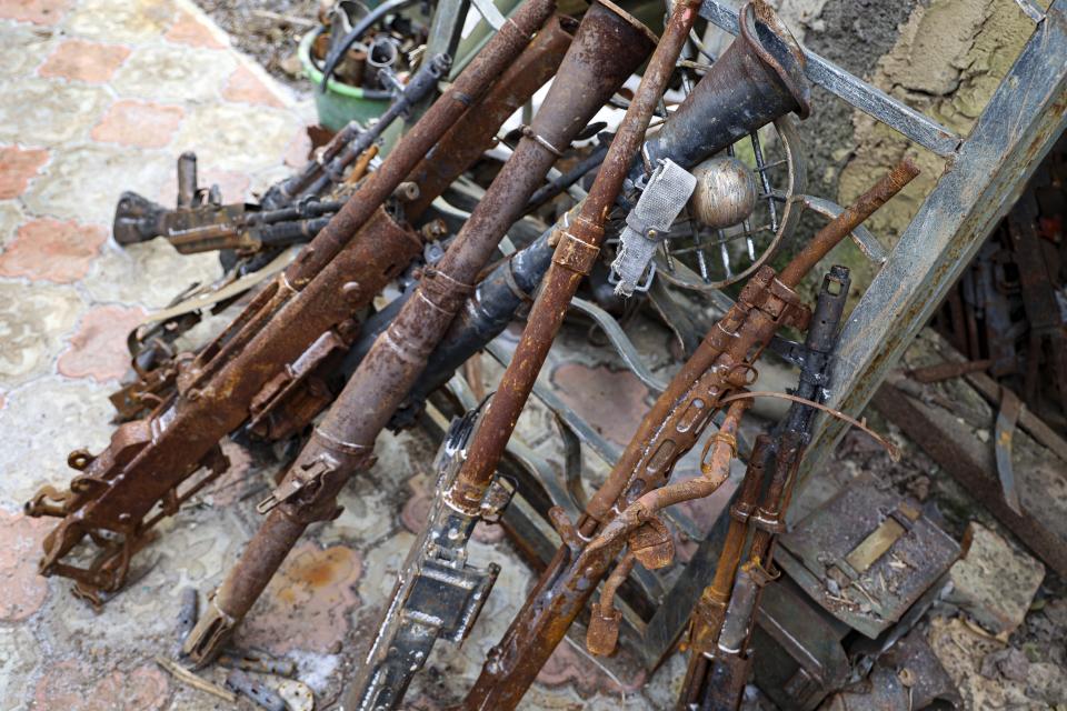 Old weapons and ammunition collected in a yard of a workshop in Viktor Mikhalev's house in Donetsk, Russian-controlled Donetsk region, eastern Ukraine, Tuesday, Jan. 24, 2023. Mikhalev is transforming weapons and ammunition into flowers of war. Mikhalev, trained as a welder, lives and works in a house whose fence and door are decorated with forged flowers and grapes. (AP Photo/Alexei Alexandrov)