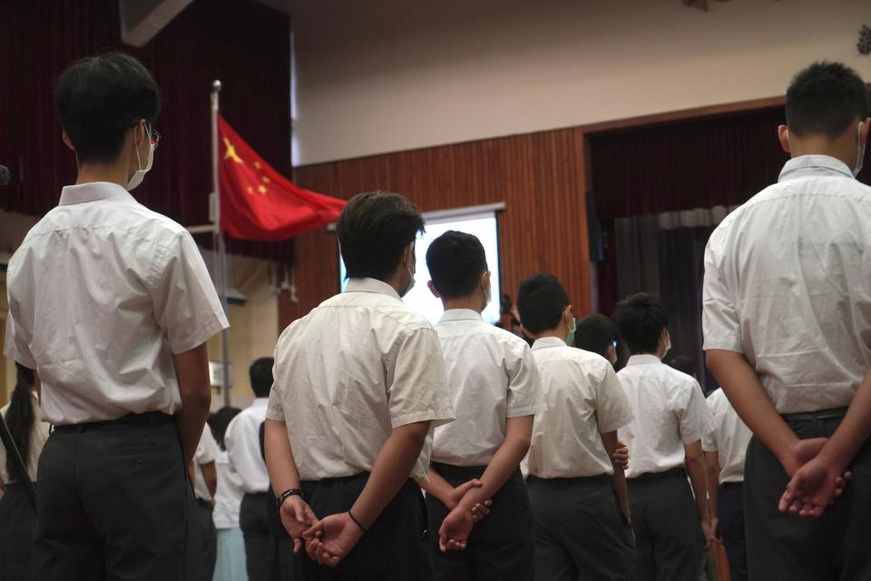 Students attend a flag raising ceremony during the National Security Education Day at a secondary school, in Hong Kong, Thursday, April 15, 2021. Beijing's top official in Hong Kong on Thursday warned foreign forces not to interfere with the "bottom line" of national security in Hong Kong, threatening retaliation even amid ongoing tensions between China and Western powers. (AP Photo/Kin Cheung)