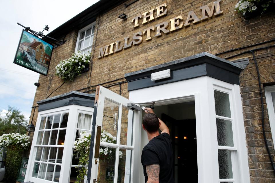 A man paints the outside of The Millstream Pub ahead of pubs reopening following the coronavirus disease (REUTERS)