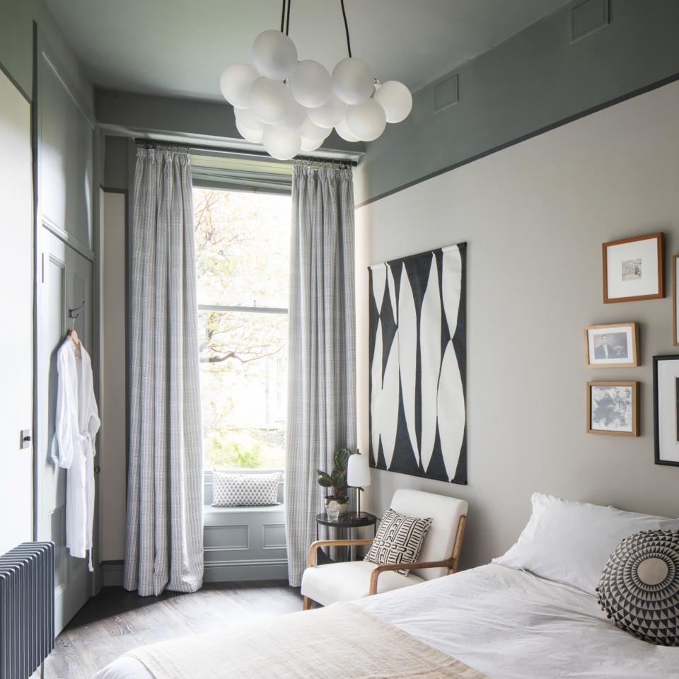 White painted bedroom with large windows, long white curtains, bed