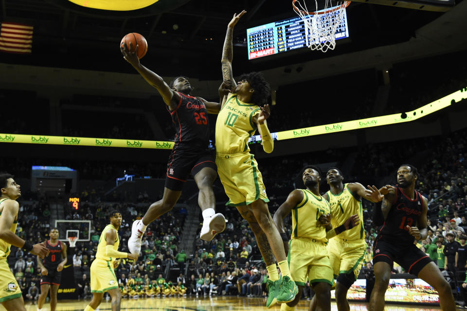 Houston forward Jarace Walker (25) drives the lane as he is defended by Oregon center Kel'el Ware (10) during the second half of an NCAA college basketball game Sunday, Nov. 20, 2022, in Eugene, Ore. (AP Photo/Andy Nelson)