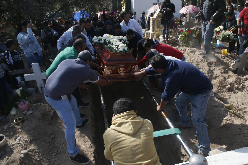 People lower the coffin of a person who died when a gas pipeline exploded in the village of Tlahuelilpan, Mexico, Sunday Jan. 20, 2019. A massive fireball that engulfed locals scooping up fuel spilling from a pipeline ruptured by thieves in central Mexico killed dozens of people and badly burned dozens more on Jan. 18. (AP Photo/Claudio Cruz)