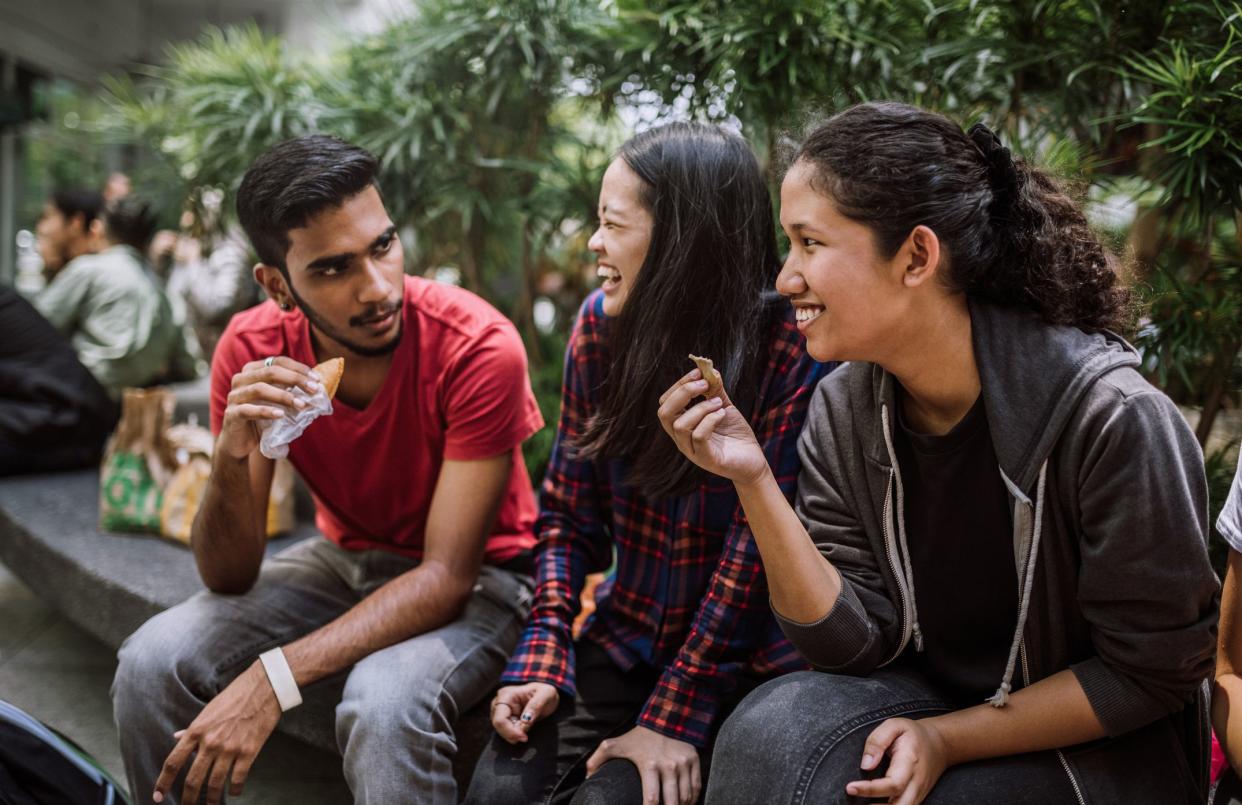 Multi Ethnic Group Of Students Joking And Getting To Know Each Other Better On Lunch Break in University Yard