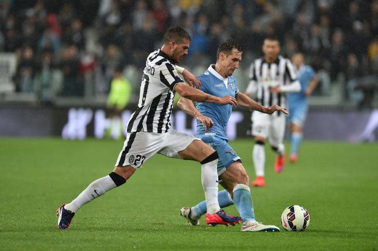 Lazio's forward from Germany Miroslav Klose (R) fights for the ball with Juventus' midfielder Stefano Sturaro during their Italian Serie A football match in Turin, Italy, on April 18, 2015