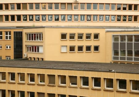 The words "feminist strike" are displayed on an office building during a women's strike in Lausanne