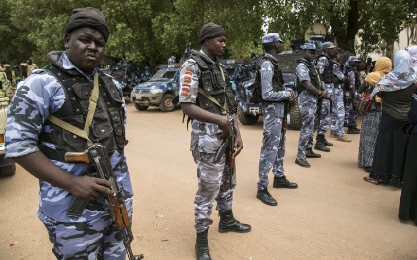 Security forces stand guard as Omar al-Bashir appears in court - GETTY